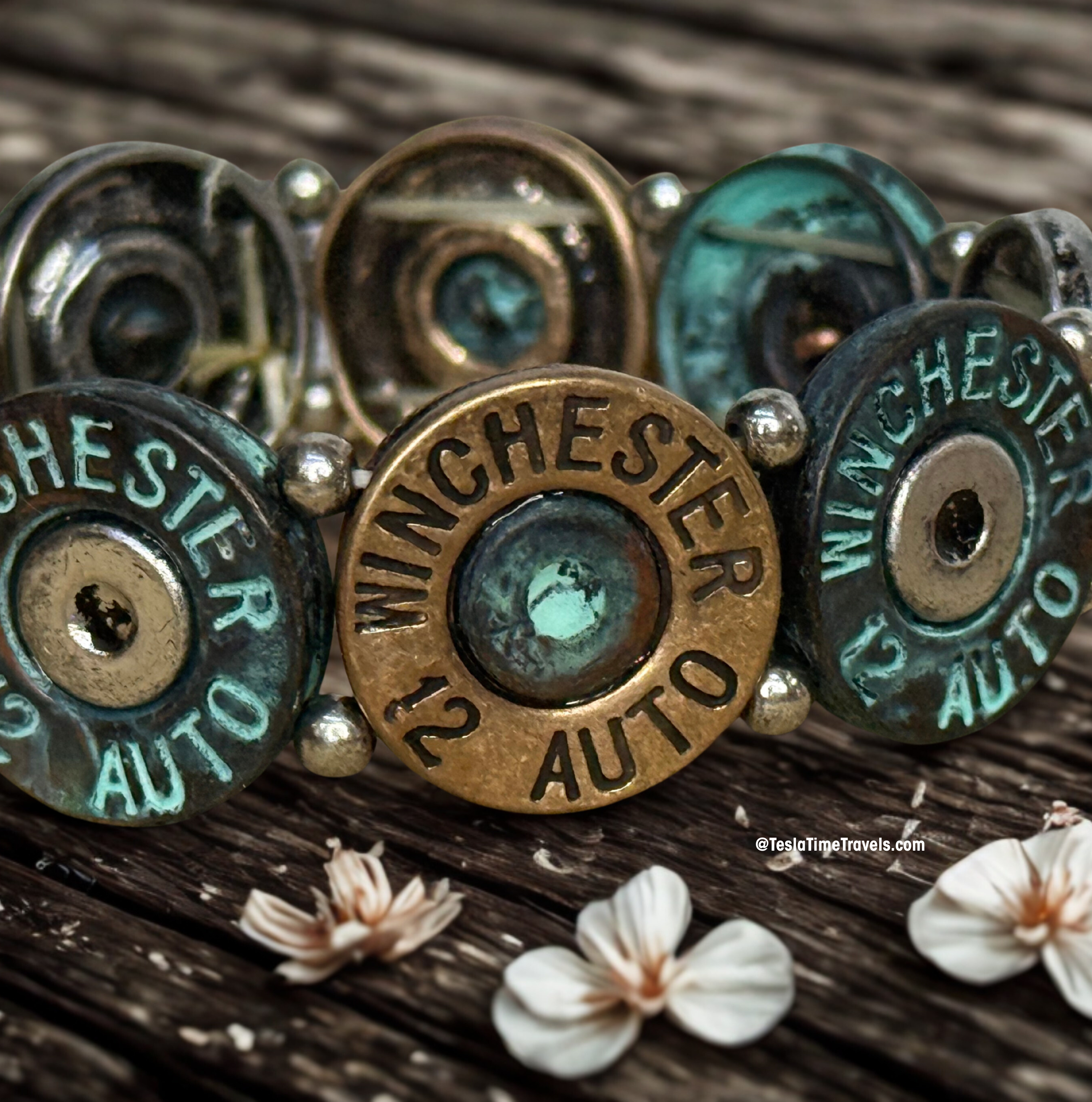 Close-up of Winchester bullet casings on a wooden surface with flowers.